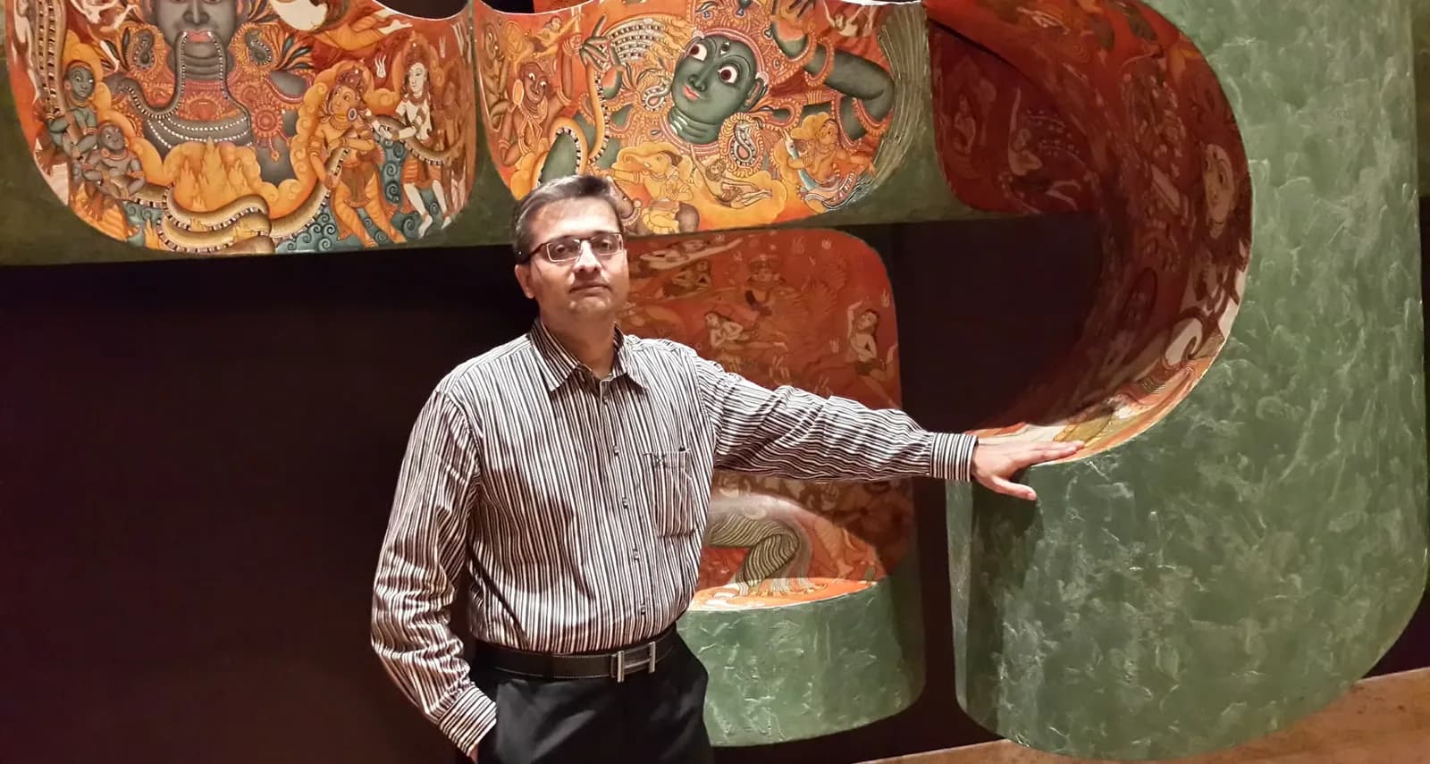 Maayank Panchal beside a hand-painted mural